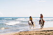 © Santi Nuñez/Stocksy - Friends Riding Horse in the Beach