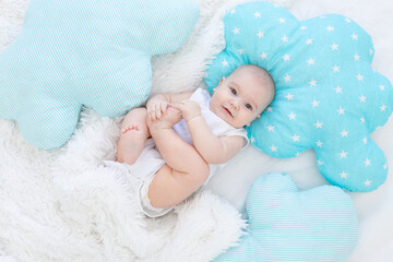 Wall Mural - baby boy lying in bed before going to bed, cute, laughing, six-month-old, smiling little baby