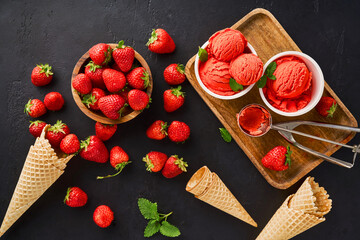 Aufkleber - Heap of strawberry with ice cream in ice cream paper cups and cones. Strawberry sorbet on black background.