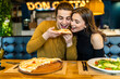 © F8  \ Suport Ukraine - Young couple sitting in a restaurant eating pizza