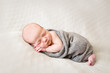 © Jennifer Bogle/Stocksy - full length photo of sleeping infant on blanket