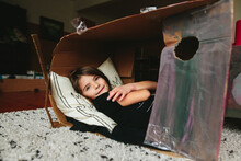 Little Girl Lays Down Inside Cardboard Box Fort