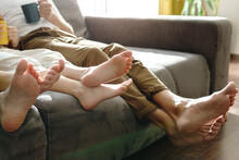 Barefoot Family Sitting On The Sofa