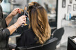 © Javier Pardina/Stocksy - Curling a client's hair