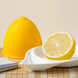 Half a lemon in a lemon plastic bowl on bamboo napkin