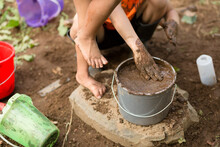 Child Steps In Bucket Of Mud