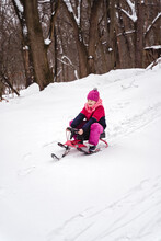 Girl Sliding Down On A Slope With A Sledge