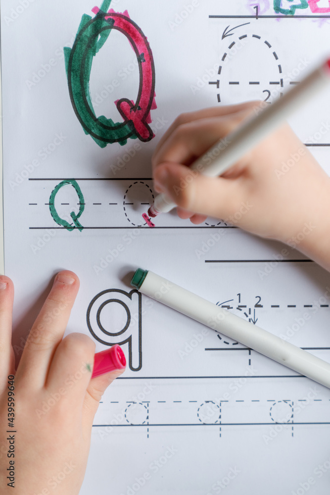 preschooler learns writing letter Q Stock Photo | Adobe Stock