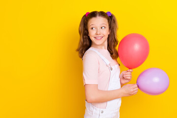 Sticker - Photo portrait schoolgirl with tails keeping air balloons looking copyspace isolated vivid yellow color background