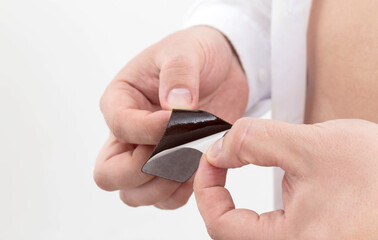 a man opens an anti-smoking plaster in his hands, close-up. nicotine addiction, protection