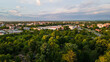 © Nenad - Top view aerial photo from flying drone of a city park with walking path and green zone trees in evening time. Aerial view of forest and city.