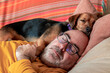 © Firnthirith - Man sleeping peacefully on the couch with his dog resting on his head
