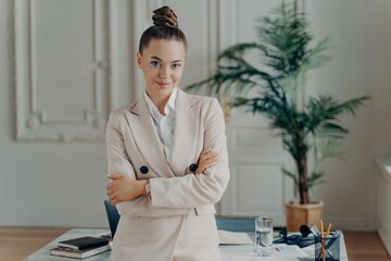 Happy businesswoman in classic wear posing in light modern office