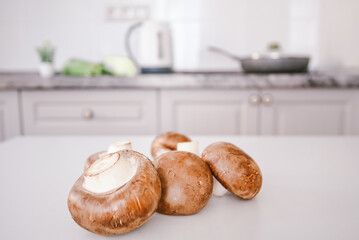 brown mushrooms on a white kitchen table. background copy space