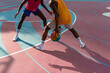 © Atolas/Stocksy - Two young African American men playing basketball.