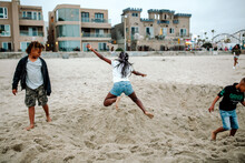 Black Girl Jumping Into Sand Pit At Beach