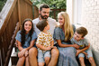 © Erin Drago/Stocksy - Family Sitting on Porch Steps Together