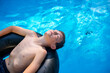© Tytia Habing/Stocksy - Teen Boy on Innertube in a Pool