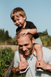 © Leah Flores/Stocksy - Young Boy Sitting on Father's Shoulders