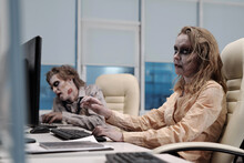 Ugly Zombie Female Sitting In Armchair In Front Of Computer Monitor