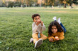 © McKinsey Jordan/Stocksy - Two Siblings Sit in the Grass at the Park and Eat Apples