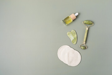 Wall Mural - Green jade face roller, gua sha stone, essential oil. Natural skin care