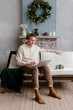 © Alina Hvostikova/Stocksy - Man using laptop on sofa on Christmas day