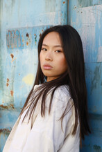  Young Chinese Woman Leaning Against Blue Wall