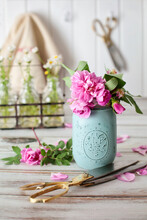 Spring Roses And Herbs In Jars On Table