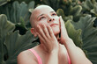 © Soledad Kubat/Stocksy - Emotional portrait of a beautiful bald woman with tattoo on her head, posing in a garden