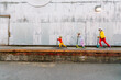 © ByLorena/Stocksy - Wide view three boys riding their scooters by a rustic metal industrial wall