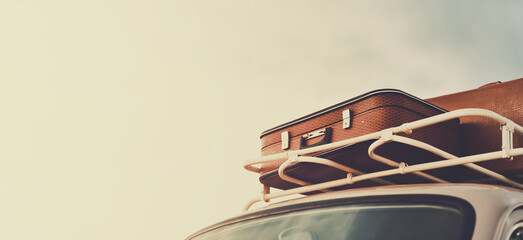 Traveling by retro car with suitcases on the roof in vintage colors