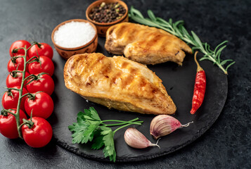 two grilled chicken breasts on a stone background