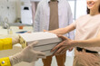 © pressmaster - Gloved hands of courier passing stack of boxes with pizza to young woman