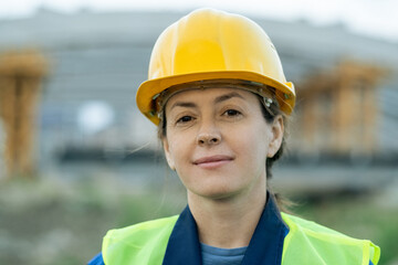 Poster - Successful female builder in protective helmet looking at you