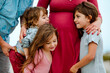 © Erin Brant/Stocksy - Pregnant woman with husband and children