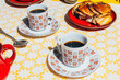 © Carmen Palma/Stocksy - Breakfast table with two cups of coffee and cinnamon rolls.