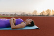 © Mihajlo Ckovric/Stocksy - Portrait of a beautiful sportswoman lying on the ground after a workout