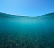 Blue sky with sea grass underwater, split view over and under water surface, Mediterranean sea