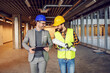 © Dusan Petkovic - Construction worker and architect walking together trough site and discussing about project they working on.