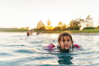 © Jessica Klaus/Stocksy - Girl swimming in pond at sunset.
