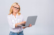 © denis_vermenko - Image of cheerful mature business woman standing isolated over white background using laptop computer. Portrait of a smiling senior lady holding laptop computer.