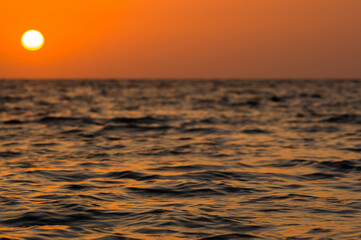 Wall Mural - Amazing sea sunset on the pebble beach, the sun, waves, clouds