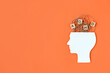 Silhouette of human head and wooden blocks with the letters ADHD on orange background. Minimal concept of attention deficit hyperactivity syndrome. Copy space