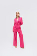 © Audrey Shtecinjo/Stocksy - Blond stylish female in pink suit .