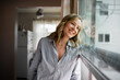 © McKinsey Jordan/Stocksy - Smiling Woman Looks Longingly Out of a Window