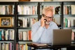 © McKinsey Jordan/Stocksy - Older Man Uses Cell Phone and Laptop While Working From Home