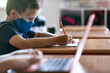 © Sean Locke/Stocksy - School: Boy Student Writing Essay At Desk