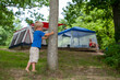 © Tytia Habing/Stocksy - Small boy in front of camping tents
