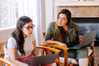 © ByLorena/Stocksy - Teen and woman with laptop sitting on armchairs